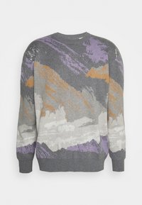 Harmaa neule, jossa on vuoristokuosi purppuran, oranssin ja valkoisen yksityiskohdilla. Valmistettu teksturoidusta neulekankaasta, jossa on pyöreä kaula-aukko.