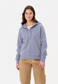 Hellgrauer Kapuzenpullover mit halber Knopfleiste, sowie gerippten Bündchen und Saum. Getragen mit beigen Cordhose. Weiches, lässiges Design.