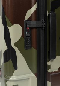 Hårdskal resväska med camouflage-mönster och strukturerad yta, med en svart dragkedja och ett kombinationslås på sidan.