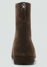 Brązowe zamszowe botki za kostkę z pionowym zamkiem z tyłu, niskim, blokowym obcasem i gładką fakturą. Prosty, elegancki design o minimalistycznym profilu.