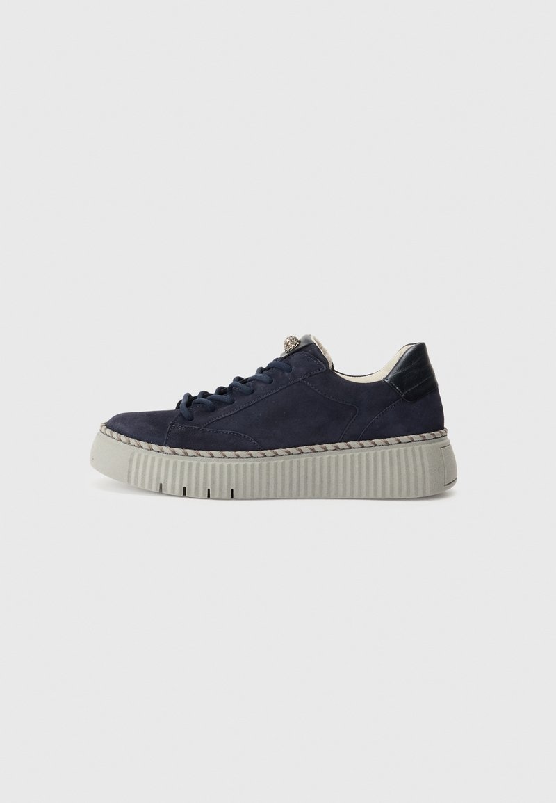 Baskets en daim bleu marine avec une semelle blanche épaisse nervurée, des lacets bleu marine et une languette de talon noire sur un fond blanc uni.