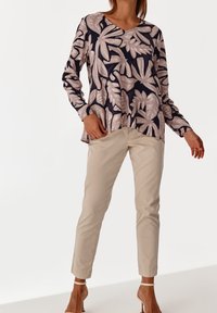 Pitkähihaiset t-paita tummansinisenä, vaaleanbeigeillä lehtikuoseilla, hieman väljä malli. Yhdistetty kermaan värisiin kapeisiin housuihin ja ihonvärisiin korkokenkiin.