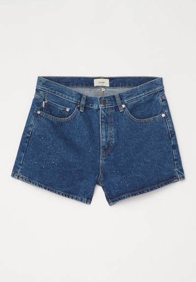 Temne modri denim kratki hlače s rahlo bledim pranjem. Imajo gumbasto zapiranje, zanke za pas in sprednje žepke z rahlimi okraski.