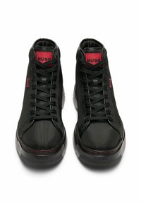Baskets montantes noires avec un dessus en textile texturé, semelle en caoutchouc et accents rouges. Comprend des lacets noirs et des étiquettes de marque sur la languette.