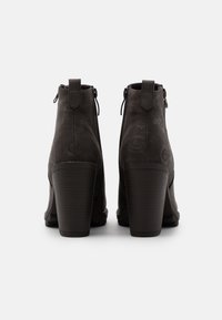 Botines negros de tacón con superficies texturizadas, que cuentan con un diseño estampado, cierres con cremallera y un robusto tacón bloque.