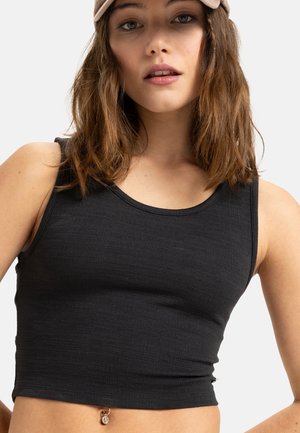 Zwarte aansluitende tanktop van gestructureerde stof, met een ronde halslijn en een cropped zoom. Bevat een kleine decoratieve accent bij de zoom.