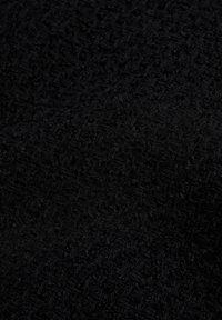 Black textured fabric featuring a densely woven pattern with a soft, plush surface, suitable for upholstery or garment applications.