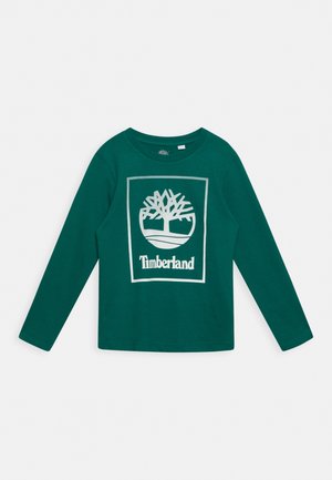 Grøn langærmet skjorte med hvid Timberland trælogo og tekst centreret på brystet.