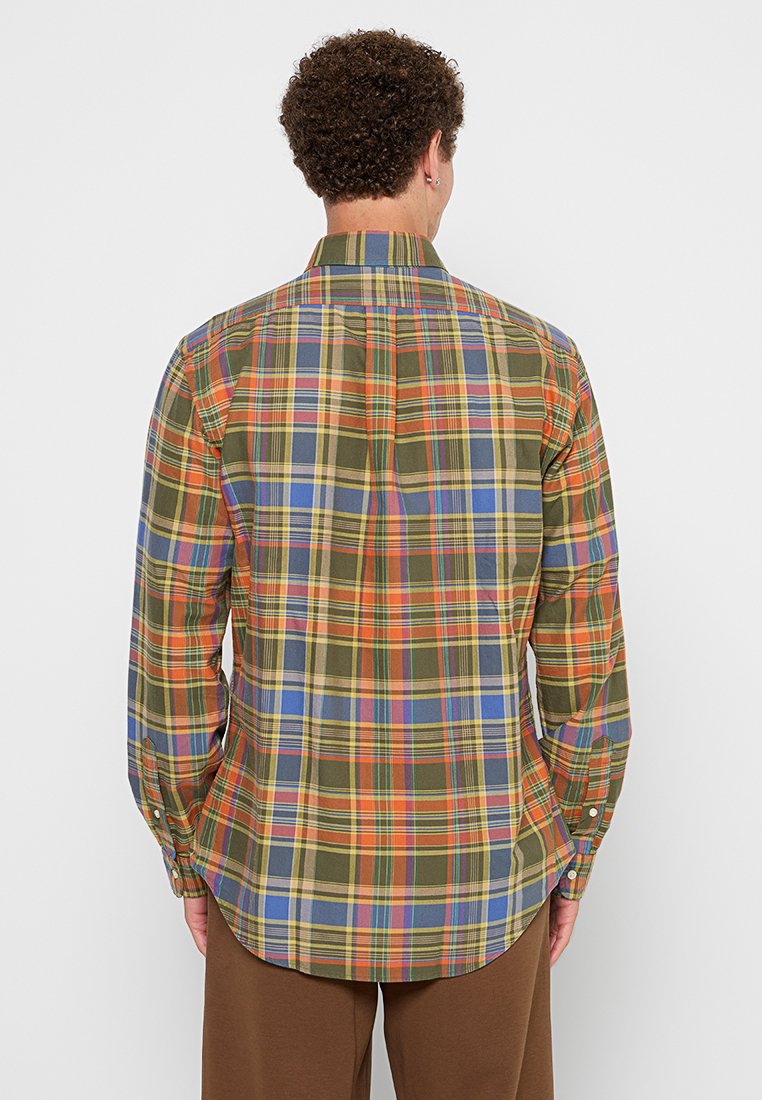 Chemise à carreaux avec un mélange de motifs en vert, jaune, orange et bleu ; coupe décontractée avec un ourlet arrondi et des manches longues.