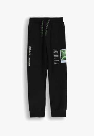 Czarne dresy z elastycznymi mankietami, z graficznym wzorem, kontrastującymi zielonymi sznurkami i białym nadrukowanym tekstem z boku.