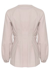 Blusa rosa cipria con maniche a sbuffo lunghe, design con schiena plissettata e vita aderente. Realizzata in tessuto di cotone leggero, con texture liscia.
