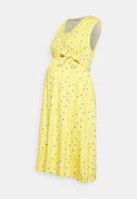 Vestido de maternidade amarelo com mangas curtas, decote em V, cintura com laço e padrão floral. Tecido leve com bolinhas e uma forma fluída.