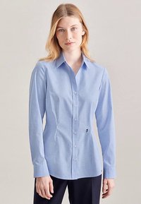 Blue checkered button-up shirt with a fitted design, long sleeves, point collar, and small embroidered logo detail near the waist.