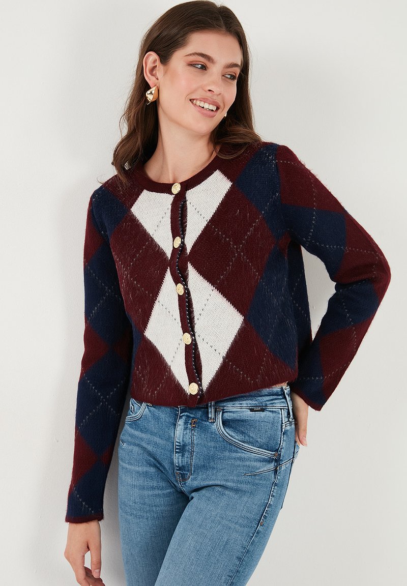 Cardigan in burgundy, navy, and cream featuring a diamond pattern, round neckline, and gold buttons. Long sleeves with relaxed fit.