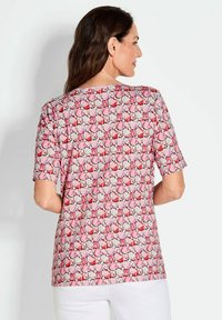 Korte mouwtop met een roze en rode geometrische print, gemaakt van een lichtgewicht stof met een relaxte pasvorm. Simpele halslijn en zoom.