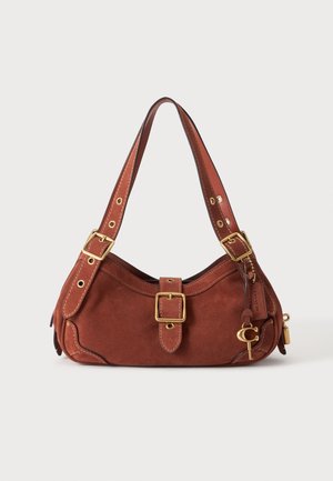 Sac à épaule en daim marron avec boucles dorées, sangle réglable et petit charm suspendu sur fond blanc.