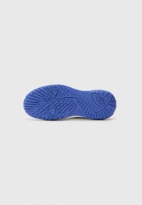 Sole of a shoe in blue rubber, featuring a textured surface with traction patterns and circular accents for grip and support.