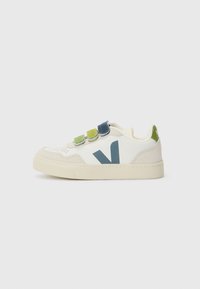 Hvit sneaker med et teksturert skinnoverdel, med en grønn, blå og gul borrelåsrem, og en kontrasterende blå logo på siden.