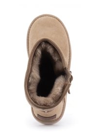 Beige suède enkellaars met een zachte bontvoering en een ronde neus. Inclusief een zijrits voor gemakkelijke toegang. Plat zoolontwerp.