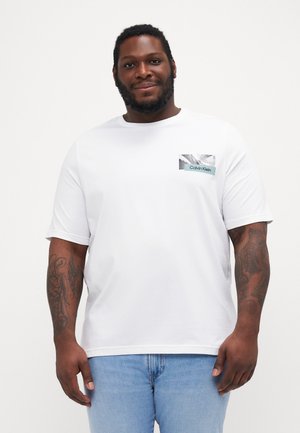 Witte katoenen t-shirt met een ronde hals, korte mouwen en een rechthoekige zak met een zwart-wit graphic en de tekst "Calvin Klein".
