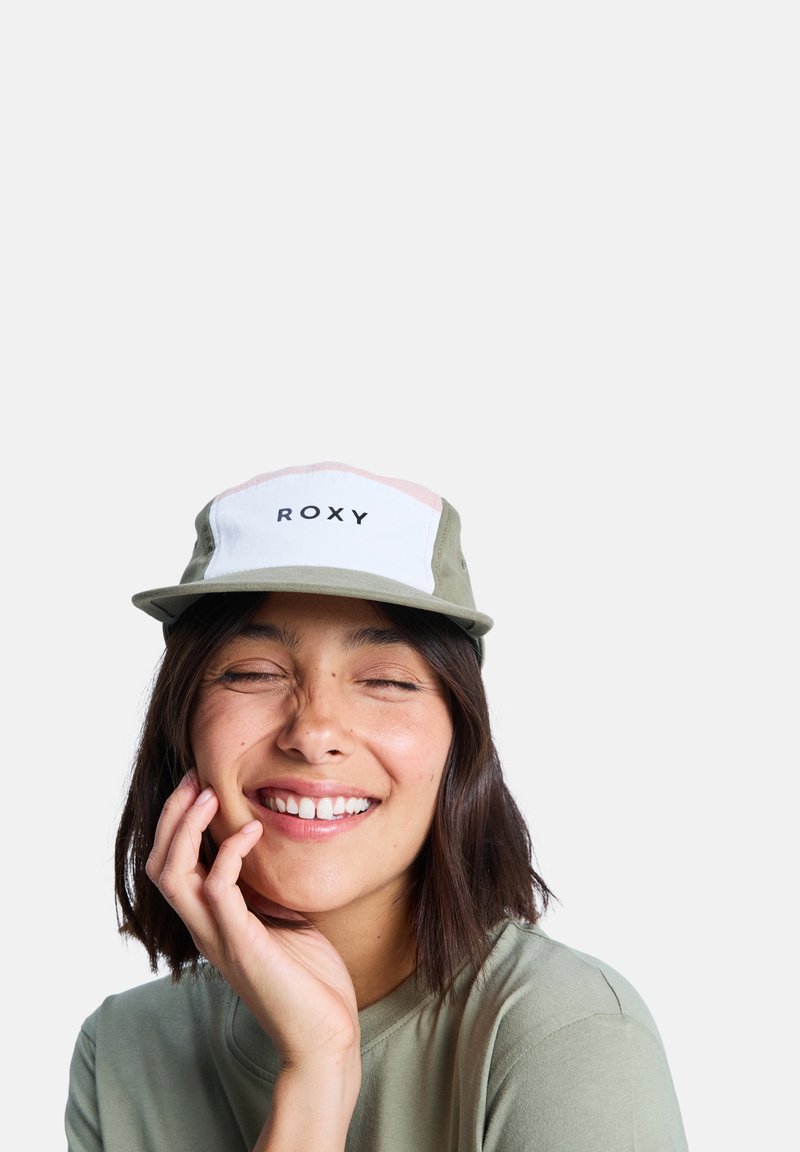 Zelená čiapka s bielou a ružovou prednou časťou, s čiernym logom "ROXY". Mäkký materiál, plochý okraj a neformálny dizajn.