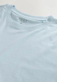 Világoskék, karcsúsított fazonú póló, puha anyagból készült, kerek nyakkivágással és egy "NEXT" feliratú, M méretű címkével. Simább textúra.