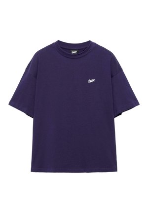 Dark purple oversized short-sleeve t-shirt with small white logo on the left chest and crew neckline.