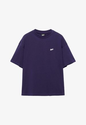 Dark purple oversized short-sleeve t-shirt with small white logo on the left chest and crew neckline.