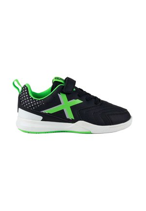 Zapatilla deportiva negra y verde con suela blanca, forro interior verde, cordones, tira de velcro y lazo trasero con acentos estampados.