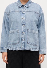 Lichtblauwe spijkerjas met knoopsluiting aan de voorkant, kraag, twee opgestikte zakken aan de voorkant en een ontspannen pasvorm met standaardmouwen.