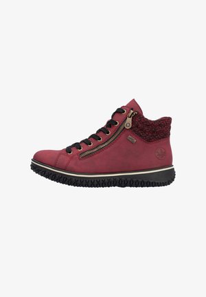 Bottine rouge avec un col en tricot texturé, lacets noirs, fermeture éclair sur le côté et semelle en caoutchouc avec un motif de semelle.