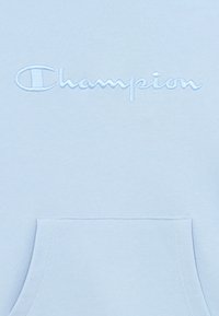 Σύντομη μπλε φούτερ Champion με κεντημένο λογότυπο, απαλό ύφασμα και μπροστινή τσέπη με ραμμένη άκρη.