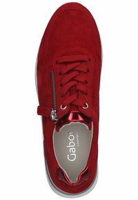 Zapatilla de ante roja con superficie texturizada, parte frontal con cordones, cremallera metálica y suela blanca en contraste. El interior presenta la marca 'Gabor comfort'.