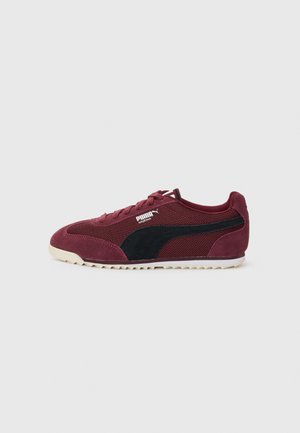 Scarpa sportiva bordeaux con pannello laterale in rete nera, suola in gomma e lacci. Presenta accenti in suede e un design a profilo basso.