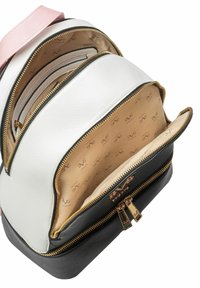 Rugzak met een witte gestructureerde buitenkant, zwarte basis en een roze schouderband. Heeft meerdere ritscompartimenten met gouden accessoires en een beige interieur.
