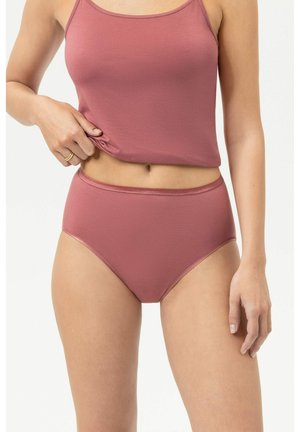 Femme portant un slip taille haute mauve et un débardeur assorti, soulevant l'ourlet du haut pour dévoiler son ventre.