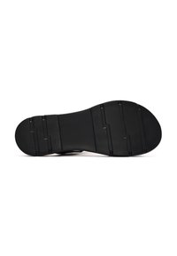 Black shoe sole with a textured finish, featuring multiple grooves and a rounded toe. Flat design suitable for various footwear styles.
