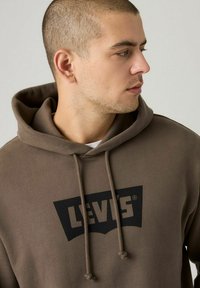 Sudadera marrón de tejido suave, con un logo negro de Levi's en la parte delantera, con cordones y un corte relajado.