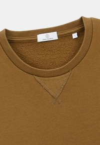 Sweat-shirt en coton brun avec un col rond côtelé et un détail de couture en V à l'avant. L'étiquette indique "SERGE BLANCO", taille L.