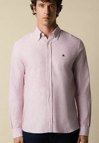 Gestreepte button-up shirt in lichtroze en wit. Heeft een kraag, lange mouwen en een klein logo op de borst. Zachte stofstructuur.