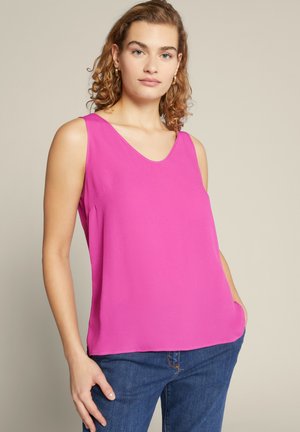 Mouwloze roze blouse met een V-hals ontwerp, gemaakt van zachte, gladde stof. Beschikt over een losse pasvorm en lichte zijsplitsingen aan de zoom.