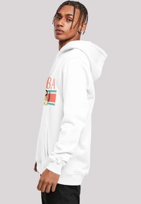 Balta kapuce ar kengūru kabatu un ribotām piedurknēm. Ievērojams ar oranžu, zilu un melnu drukātu dizainu, ar grafiskajiem elementiem uz priekšpuses.