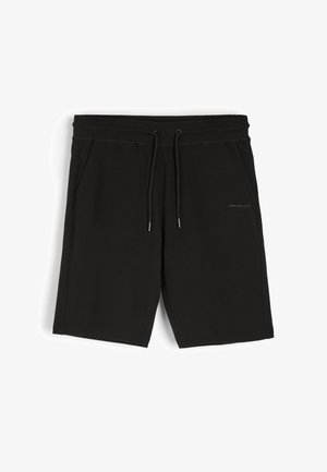 Czarne bawełniane szorty z elastycznym paskiem w talii, regulowanym sznurkiem oraz dwiema bocznymi kieszeniami. Posiadają subtelny detal z logo z przodu.