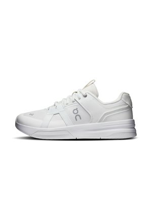 Baskets blanches de sport avec panneaux en mesh et cuir, fermeture à lacets et semelle épaisse, vues de côté sur fond blanc.