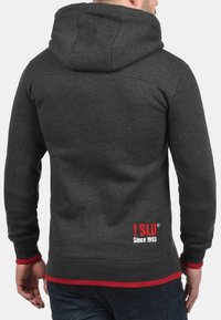 Grey hooded sweatshirt with red accents, featuring a drawstring hood, ribbed cuffs, and a logo print on the lower back.