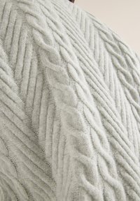Lichtgrijze gebreide sweater met een verhoogd kabelpatroon met diagonale lijnen en een zachte, gestructureerde afwerking.
