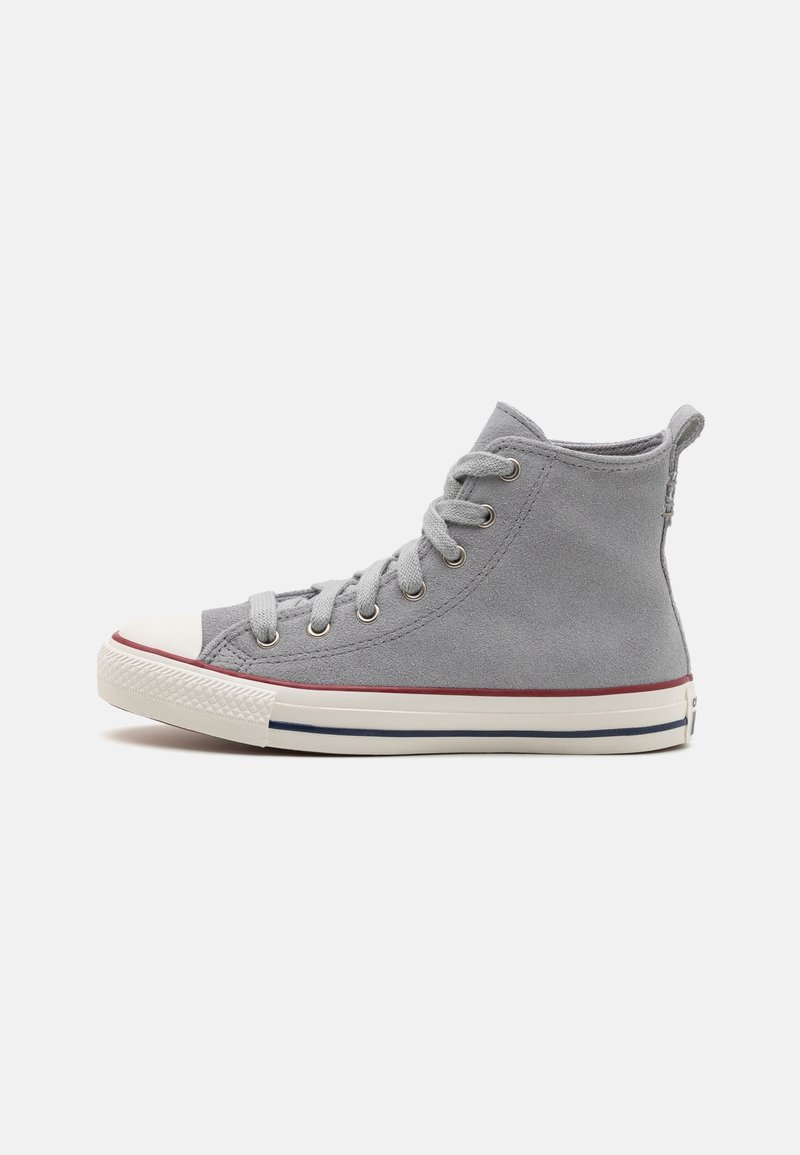 Baskets montantes grises avec semelle en caoutchouc blanche, rayures rouges et bleues, bout blanc et lacets gris sur fond uni.