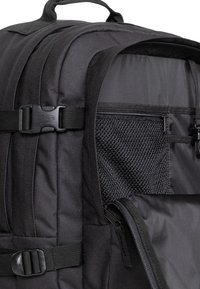 Black backpack featuring durable fabric, adjustable shoulder straps, side pockets, a mesh pocket, and buckle closure details.