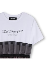 Tricou alb cu text negru "Karl Lagerfeld FRENCH RIVIERA" și pliseu decorativ din tull negru la tiv. Țesătură moale și croială lejeră.