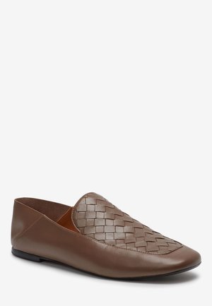 Des mocassins en cuir marron avec un motif tissé à l'avant, une pointe arrondie et une semelle plate. Texture lisse avec une finition mate.